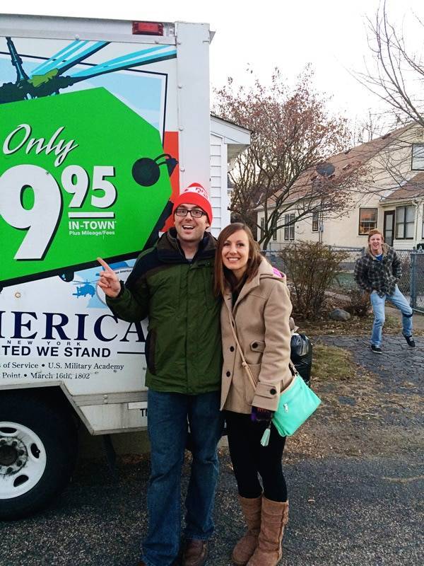 Man and woman standing by a moving truck.