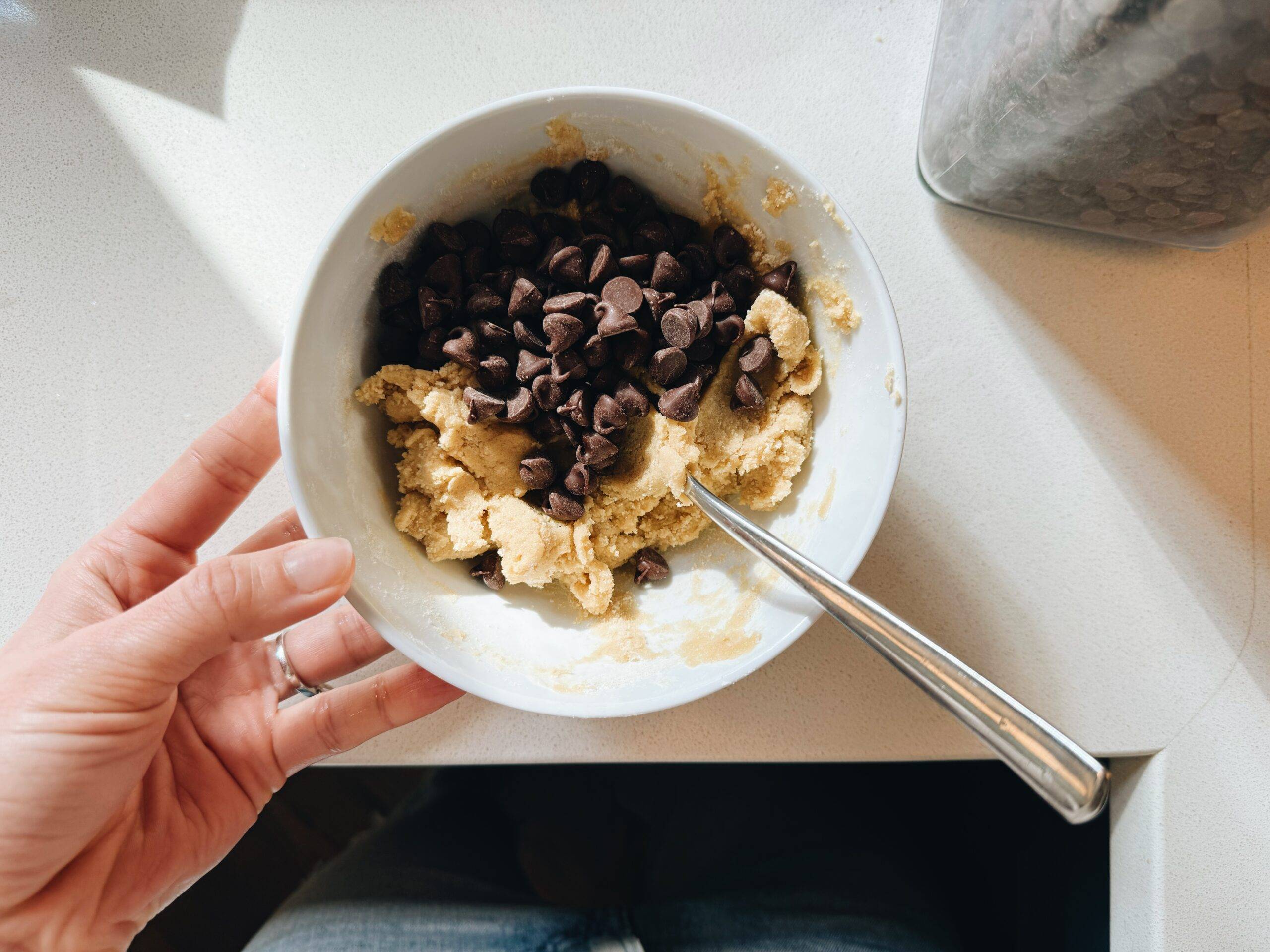 Stirring chocolate chips into cookie batter.