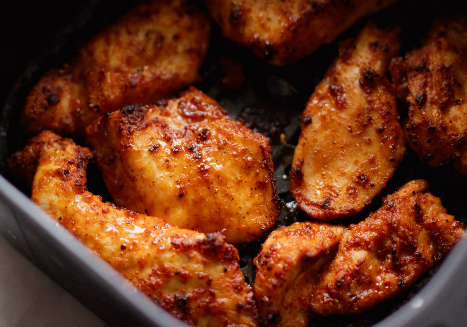 Chicken in air fryer basket after cooking.