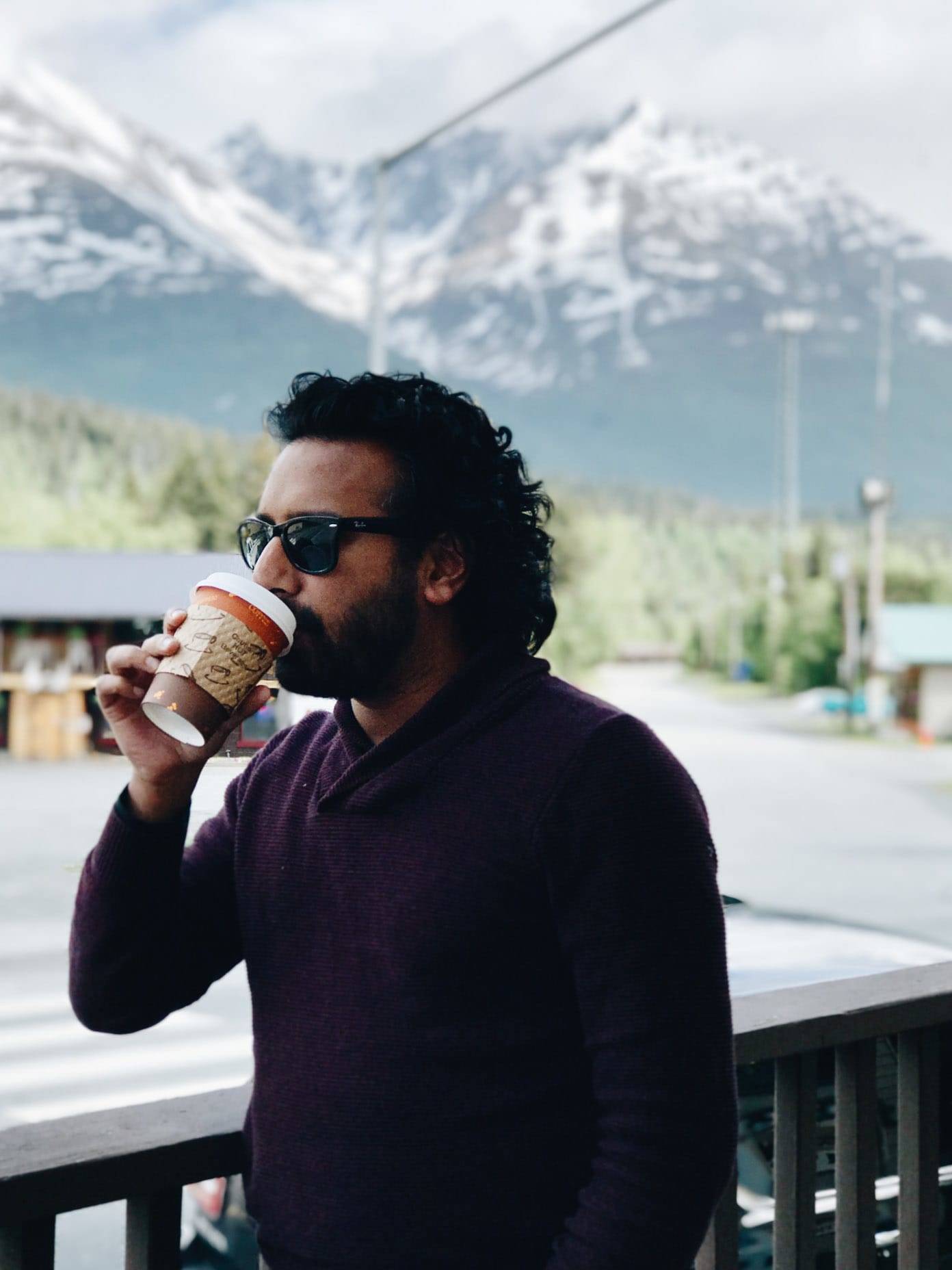 Man drinking out of a cup.