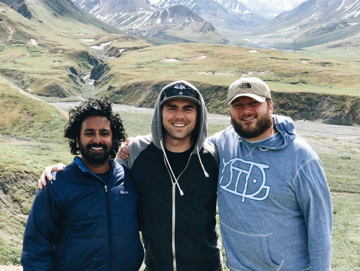 Three men smiling.