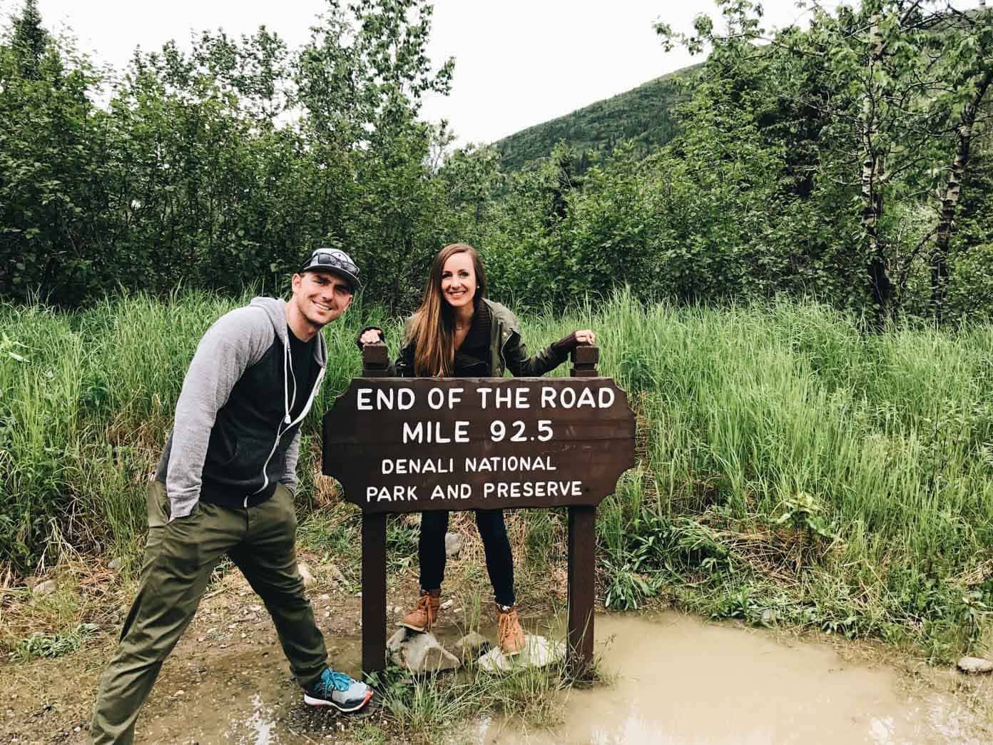 Man and woman standing in front of a sign.