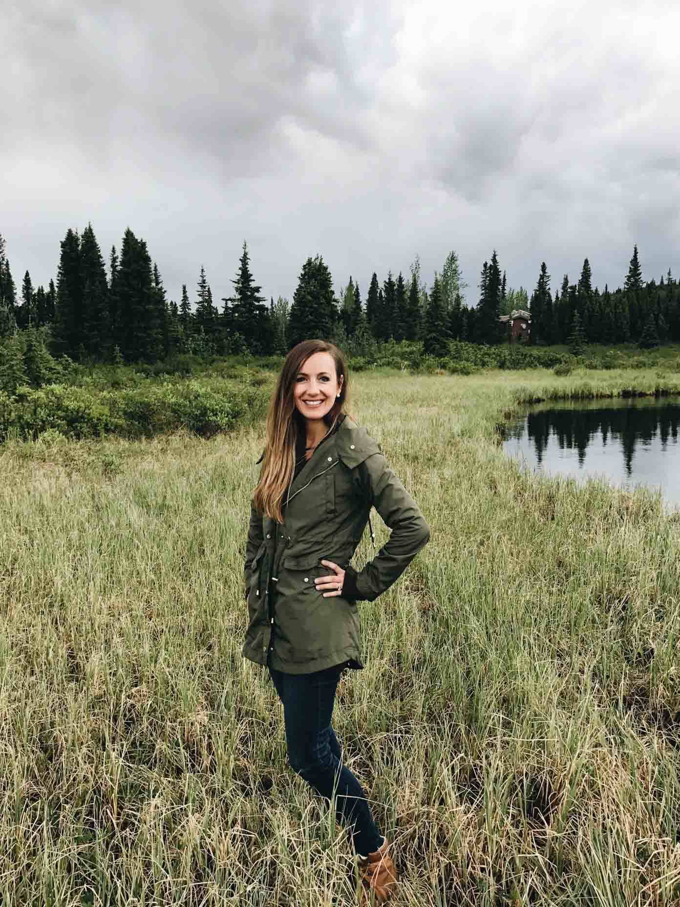 Woman standing in tall grasses.