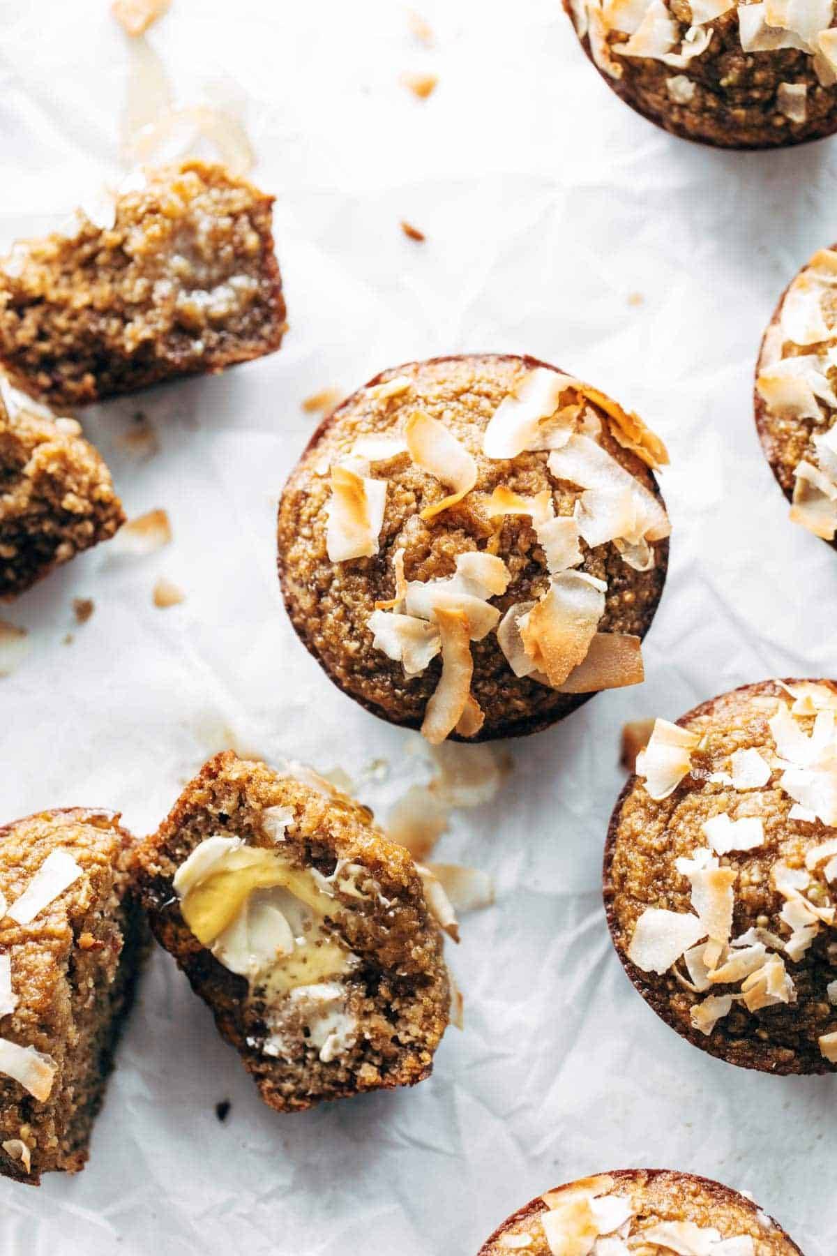 Apple muffins with coconut flakes on parchment.