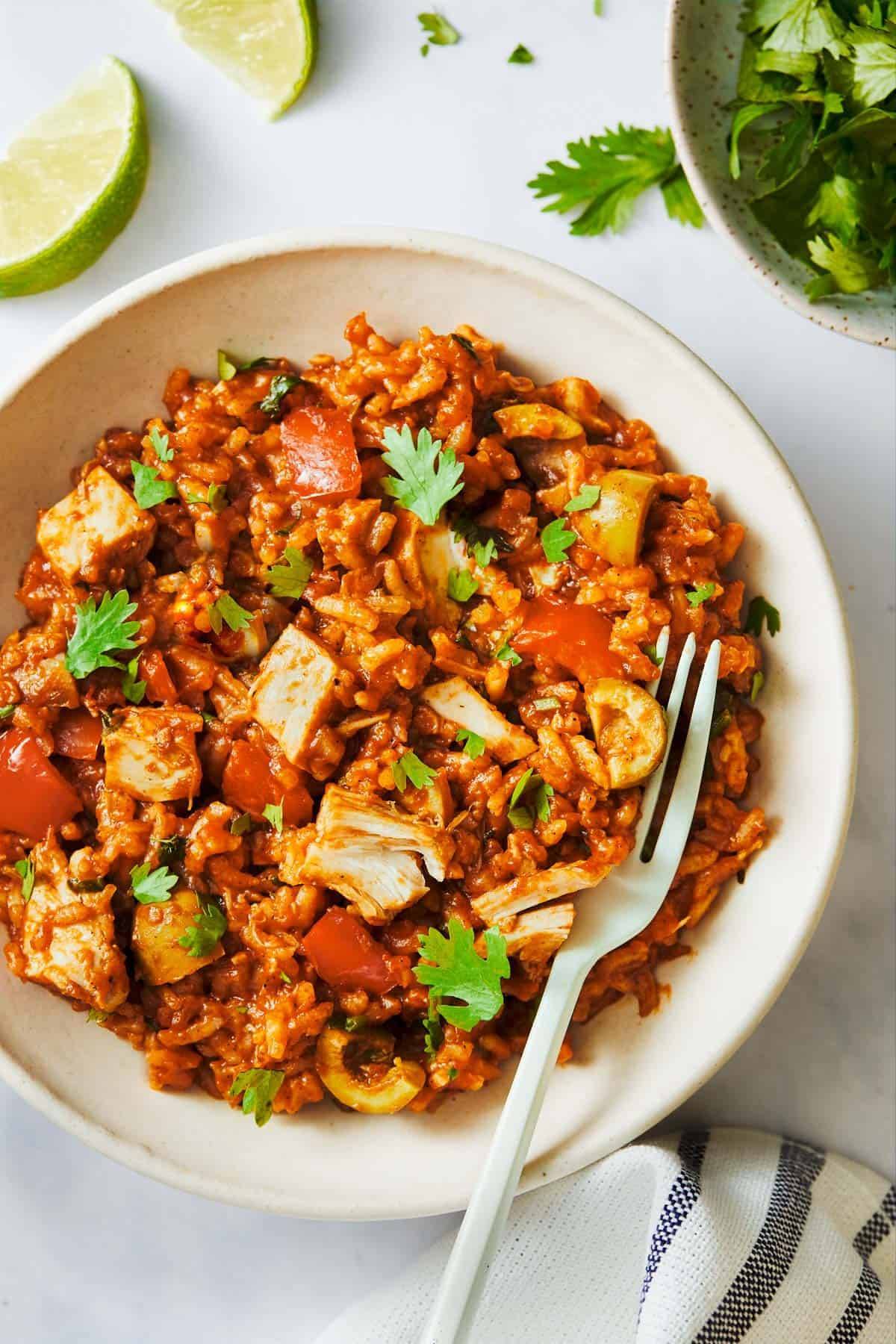 Arroz Con Pollo in a bowl with a fork.