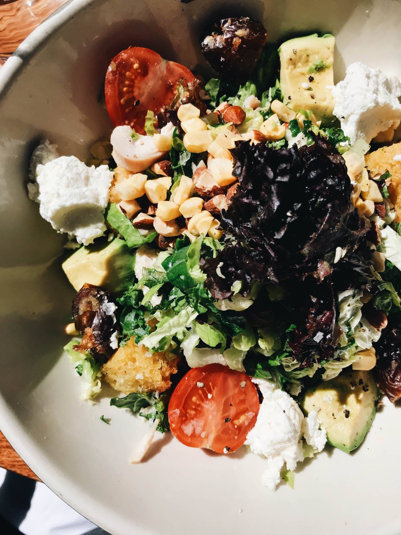 A bowl of salad filled with different vegetables and chickpeas.