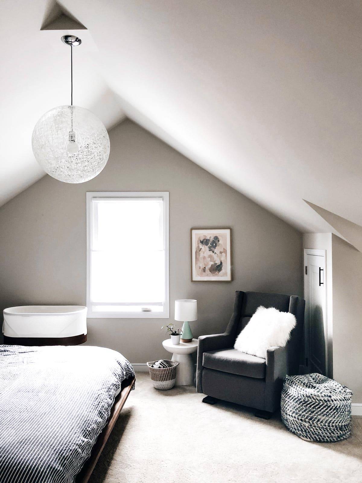 A chair and a bed near a window of a bedroom.