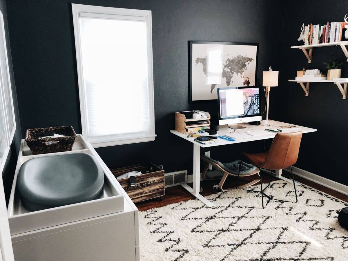 A home office a personal computer, table-chair and window next to it.