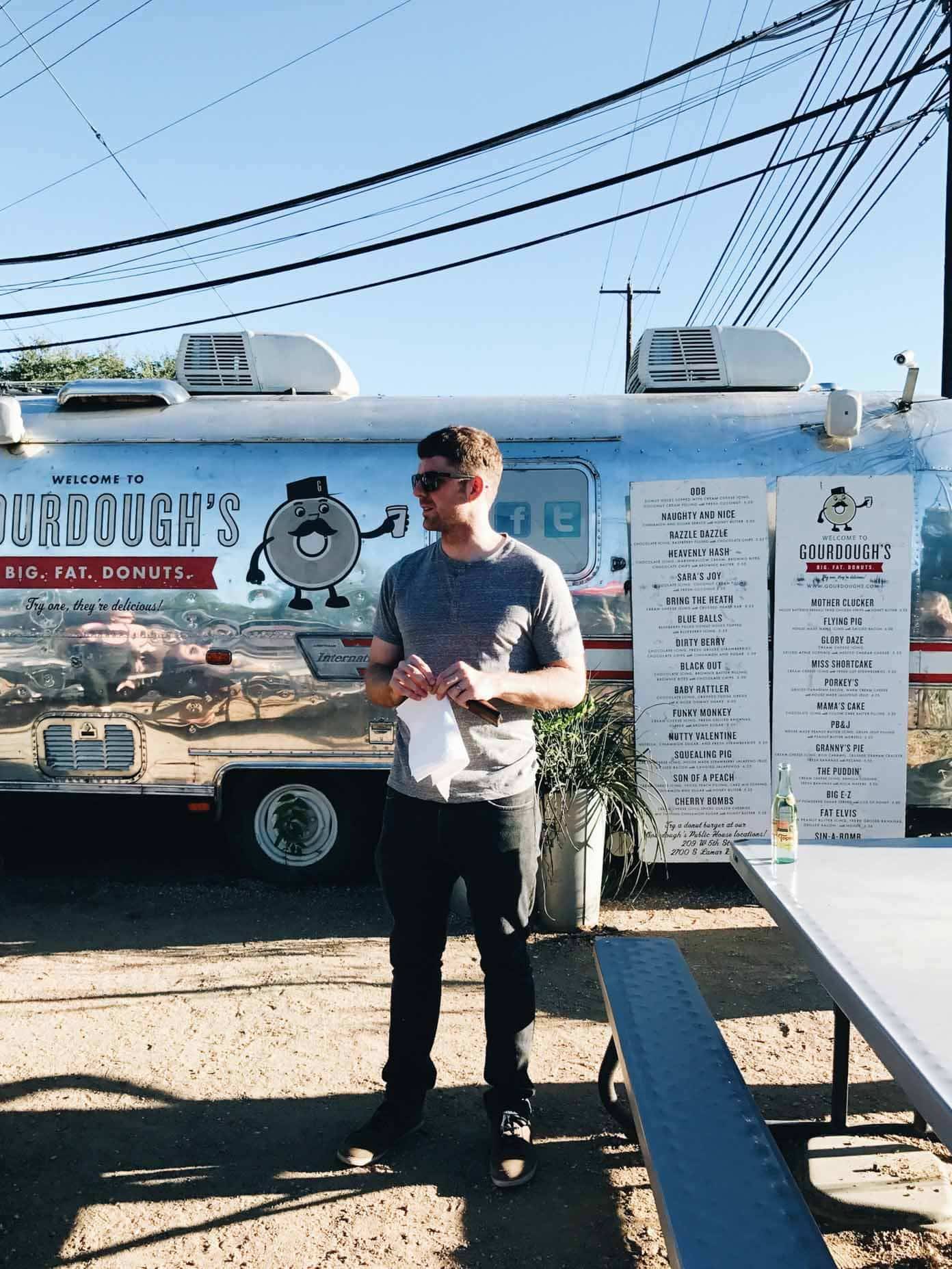 Man standing near a donut shop.