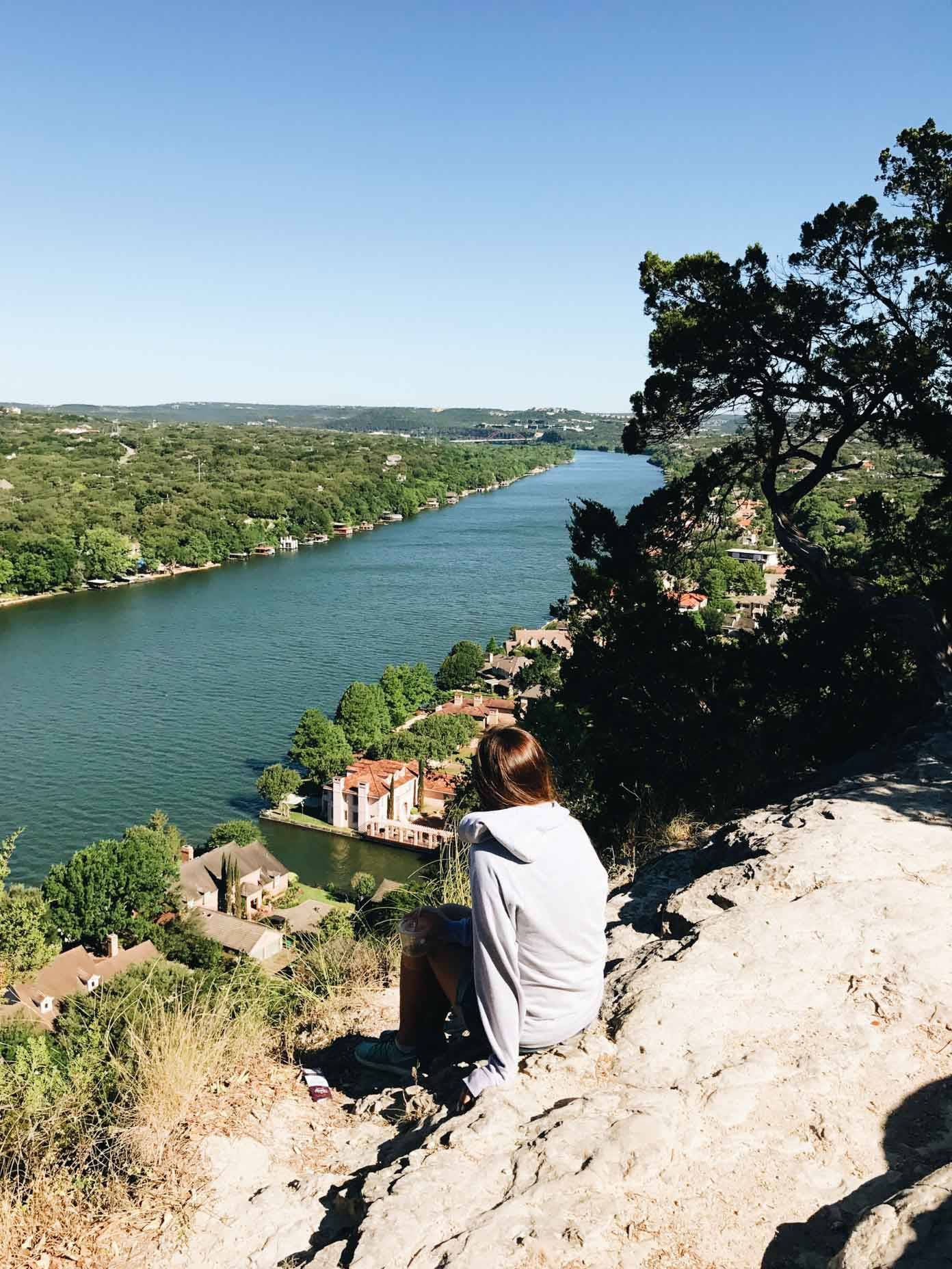 Woman sitting on a cliff.