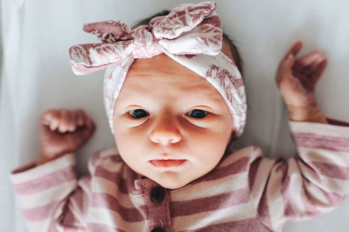 A baby in striped pajamas stretches out.