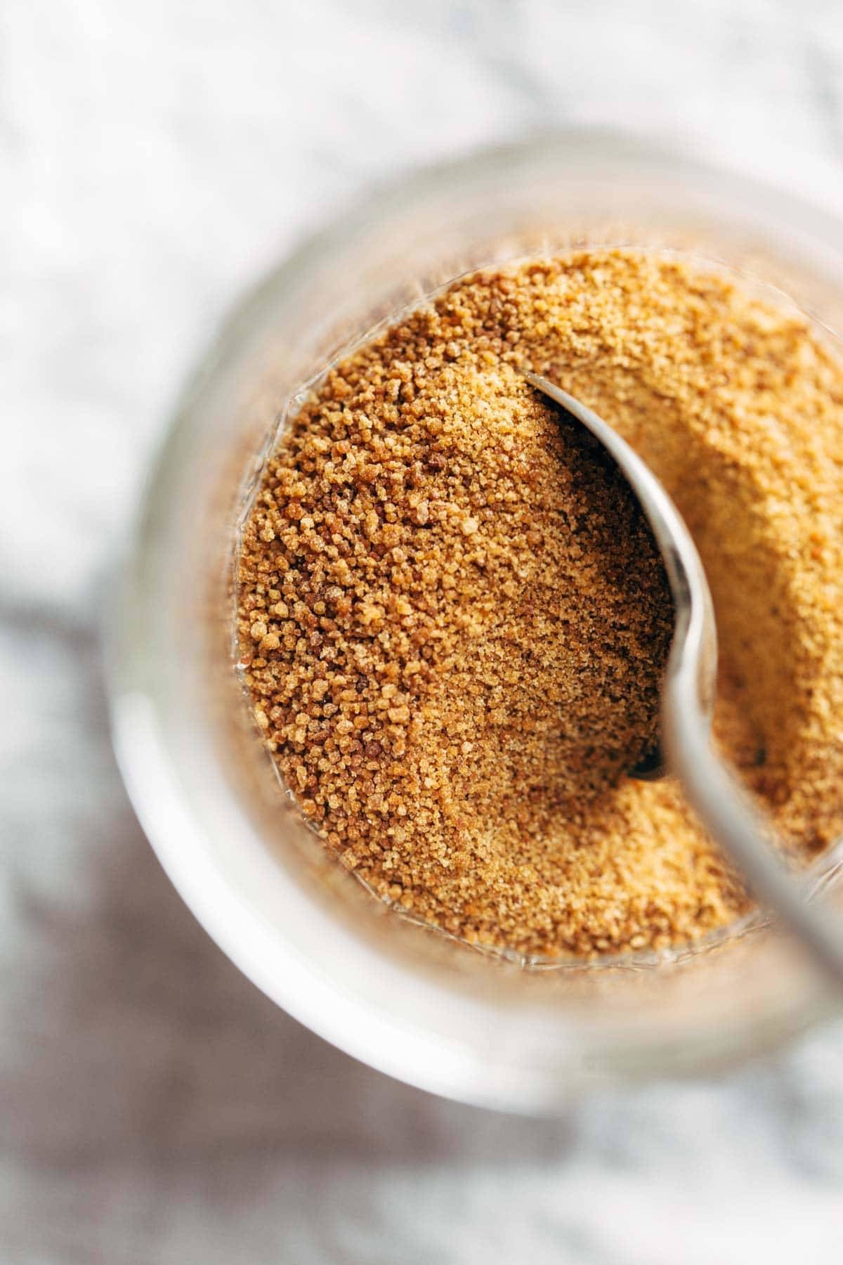 Coconut palm sugar in a jar with a spoon.