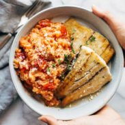 Barrumundi fish with tomato risotto on a plate.