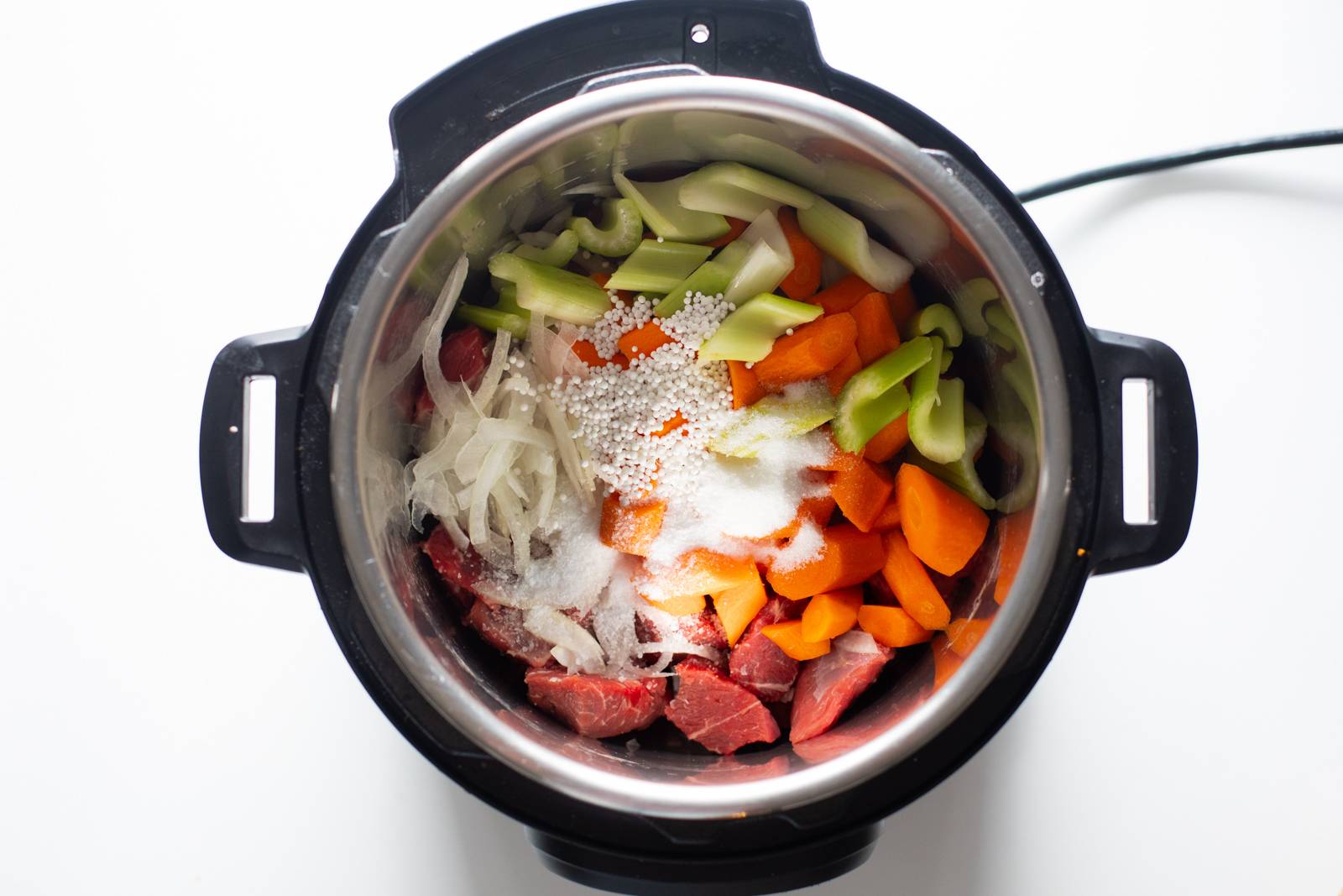 Ingredients for beef stew in an Instant Pot before cooking.