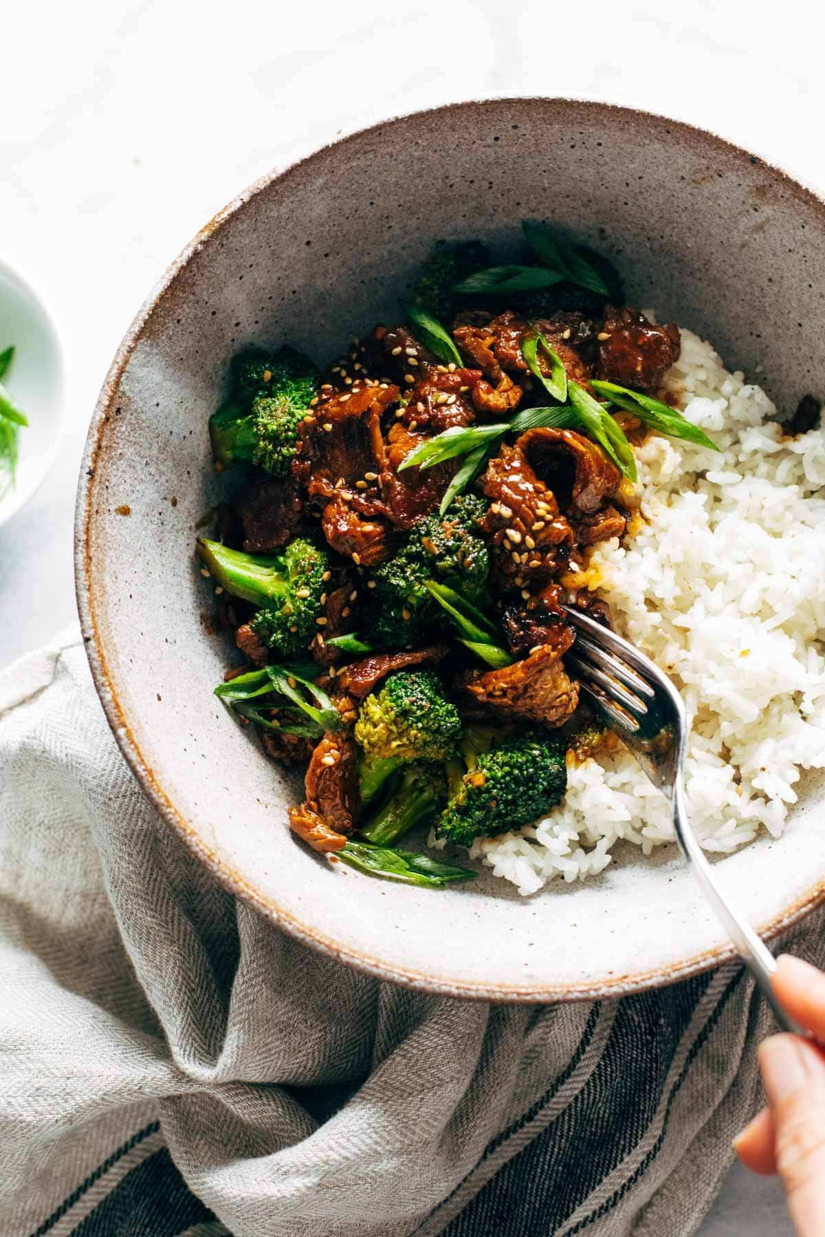 Beef and broccoli in a bowl with a fork.