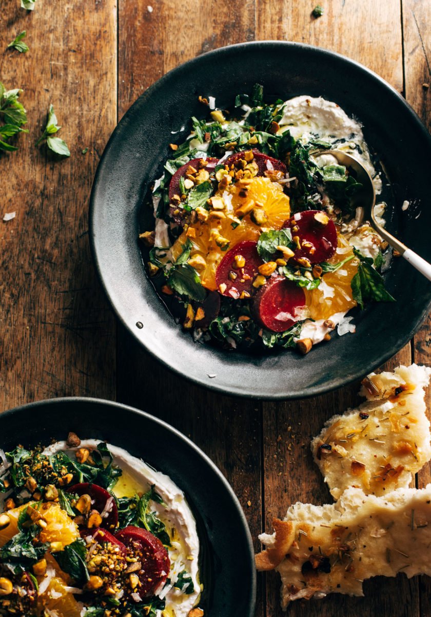 Beet salad in a bowl with whipped feta and garnishes