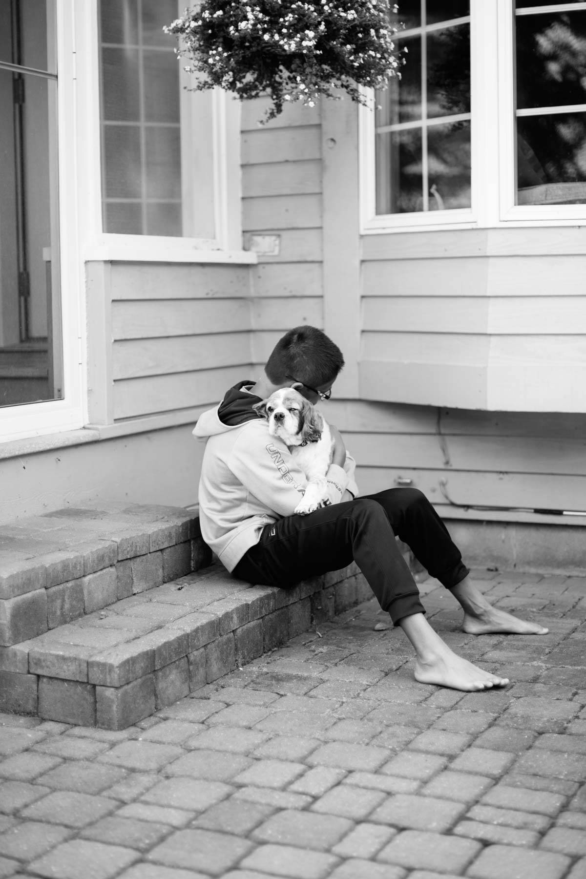 Boy holding a dog.