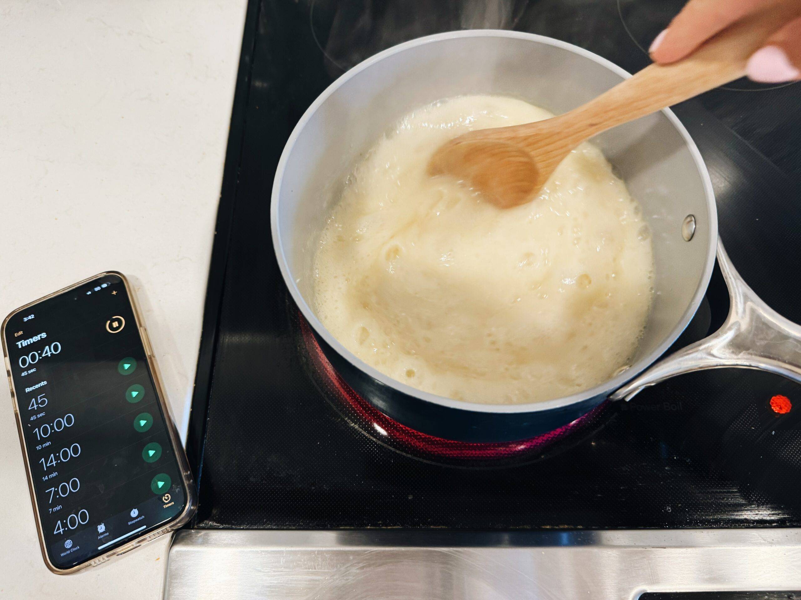 Boiling butter, milk, and sugar in pot on the stove.