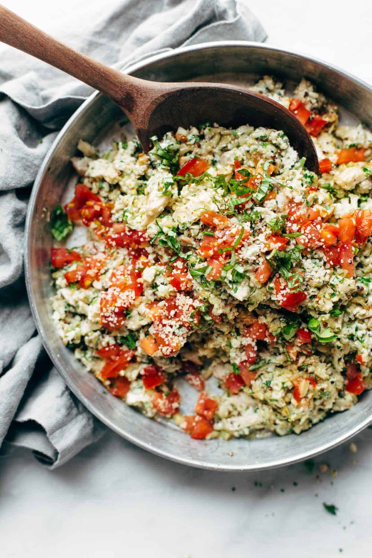 Chicken salad in a bowl with a wooden spoon.