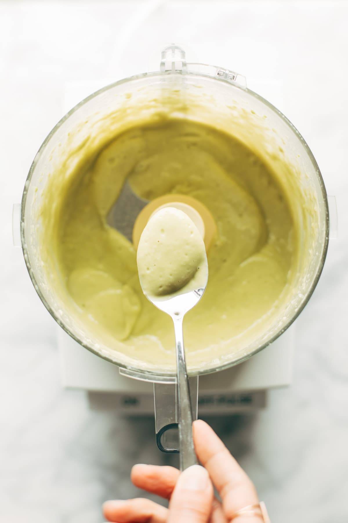 Avocado caesar dressing in a food processor.