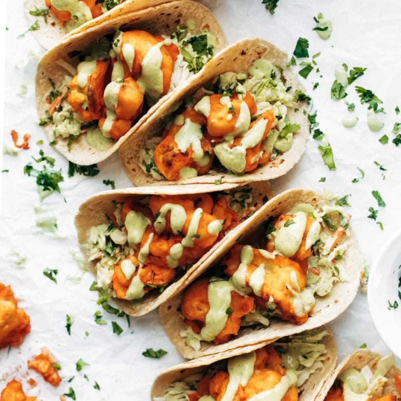 Buffalo Cauliflower Tacos on table in a row.