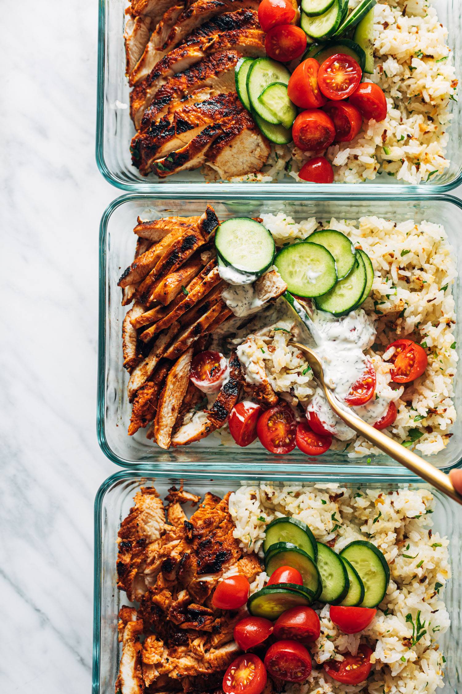 Buffalo chicken bowls in three meal prep containers.