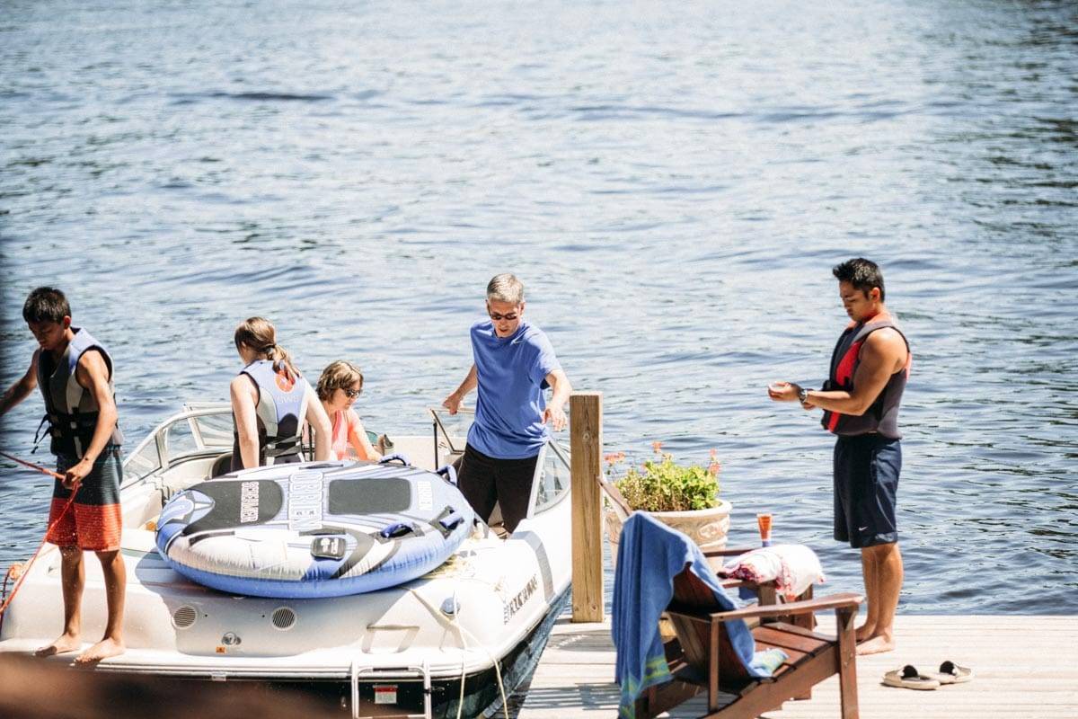 People on a boat near a dock on the lake.