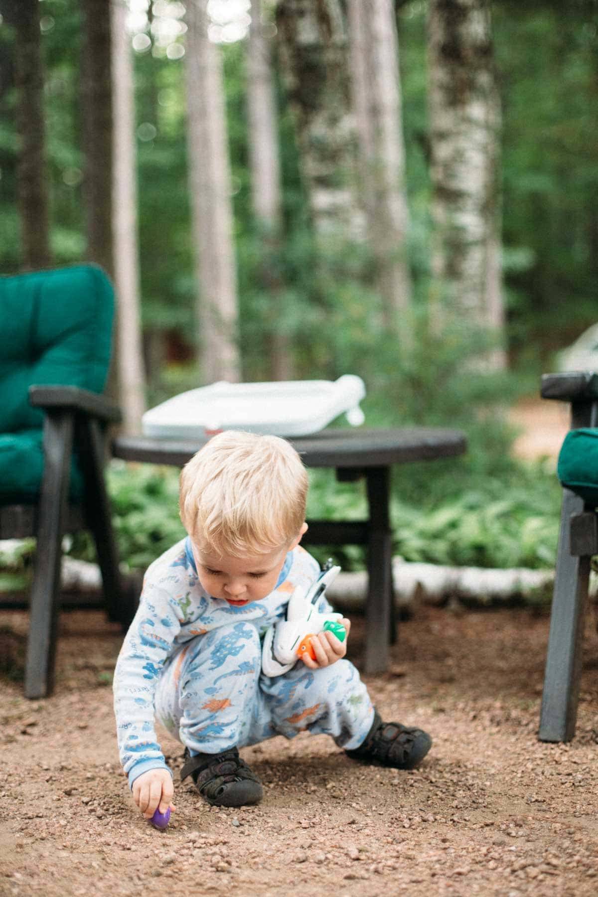 Little boy playing in dirt.