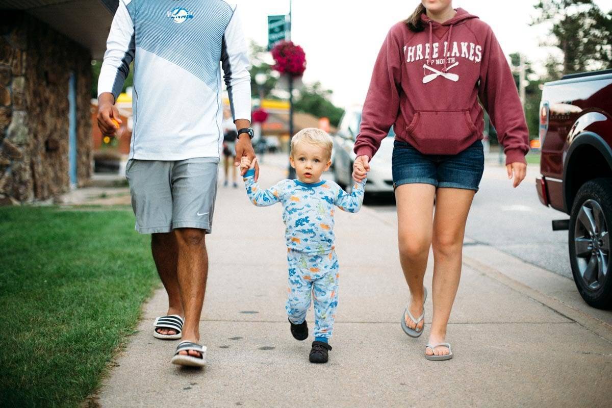 Girl and boy holding hands with a young boy.