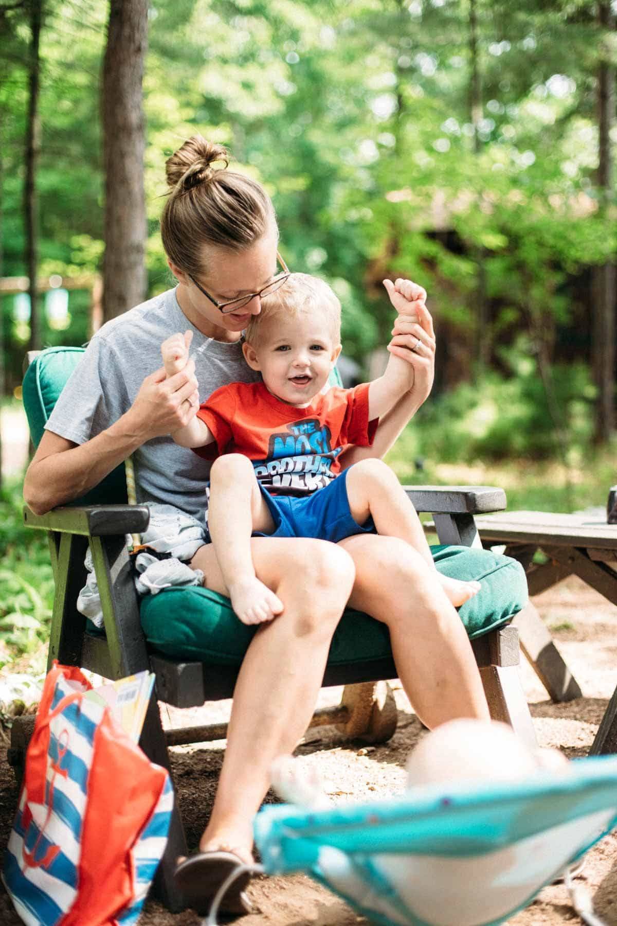 Woman holding a young boy in a chair.