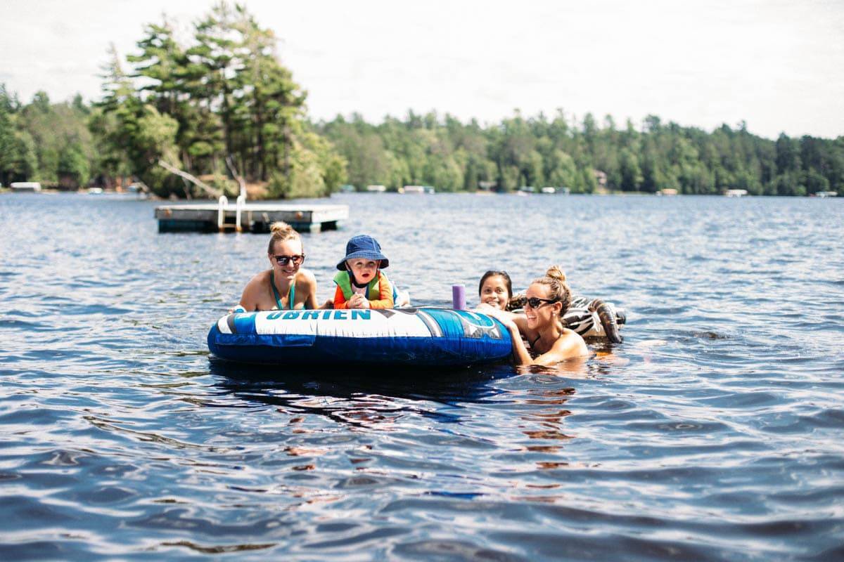 People hanging around a tube in a lake.