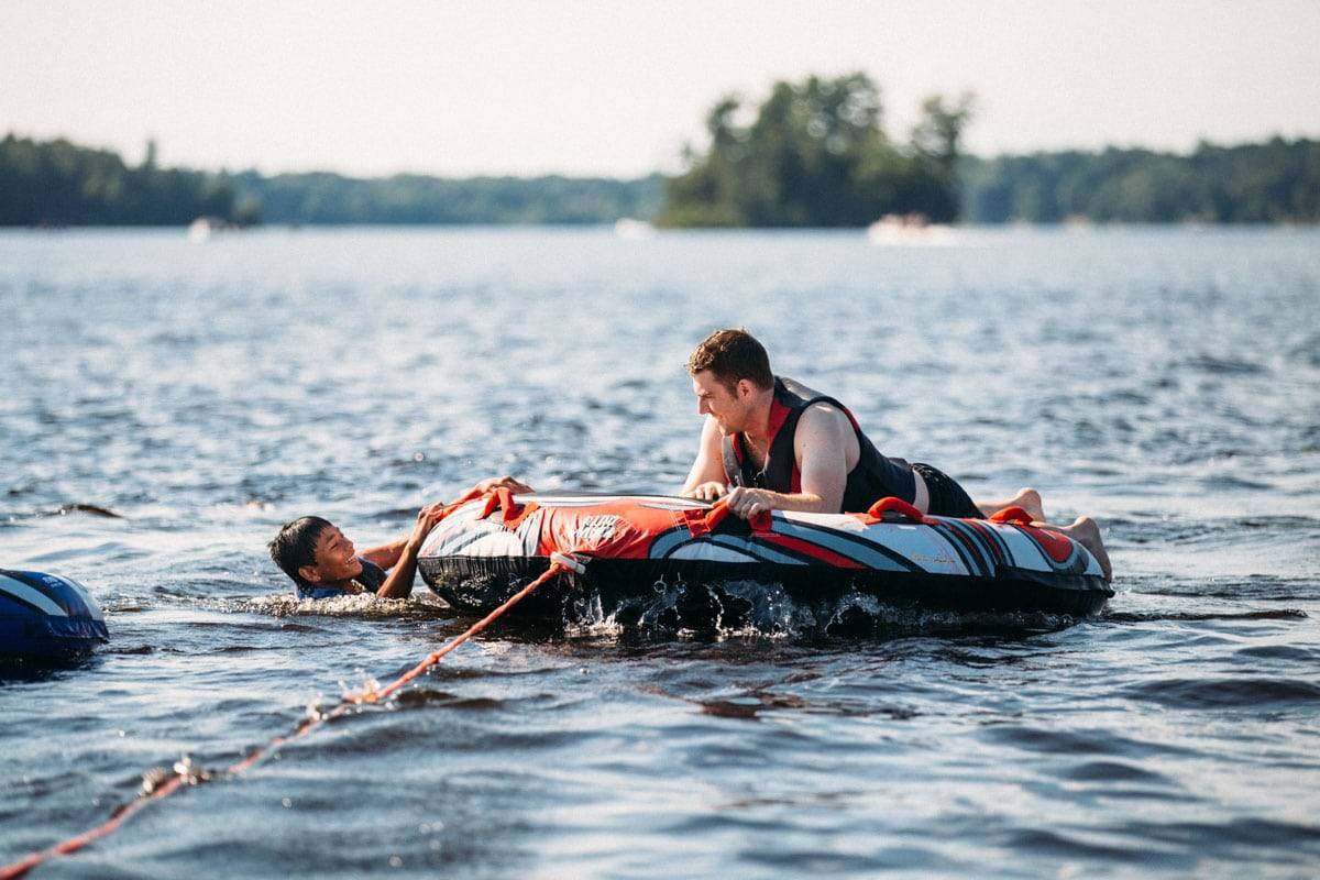 Two men tubing on a lake.