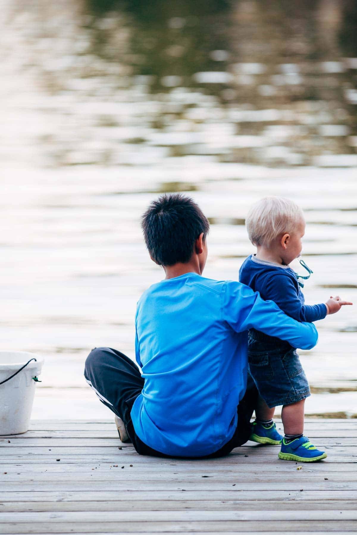 Boy holding a toddler.