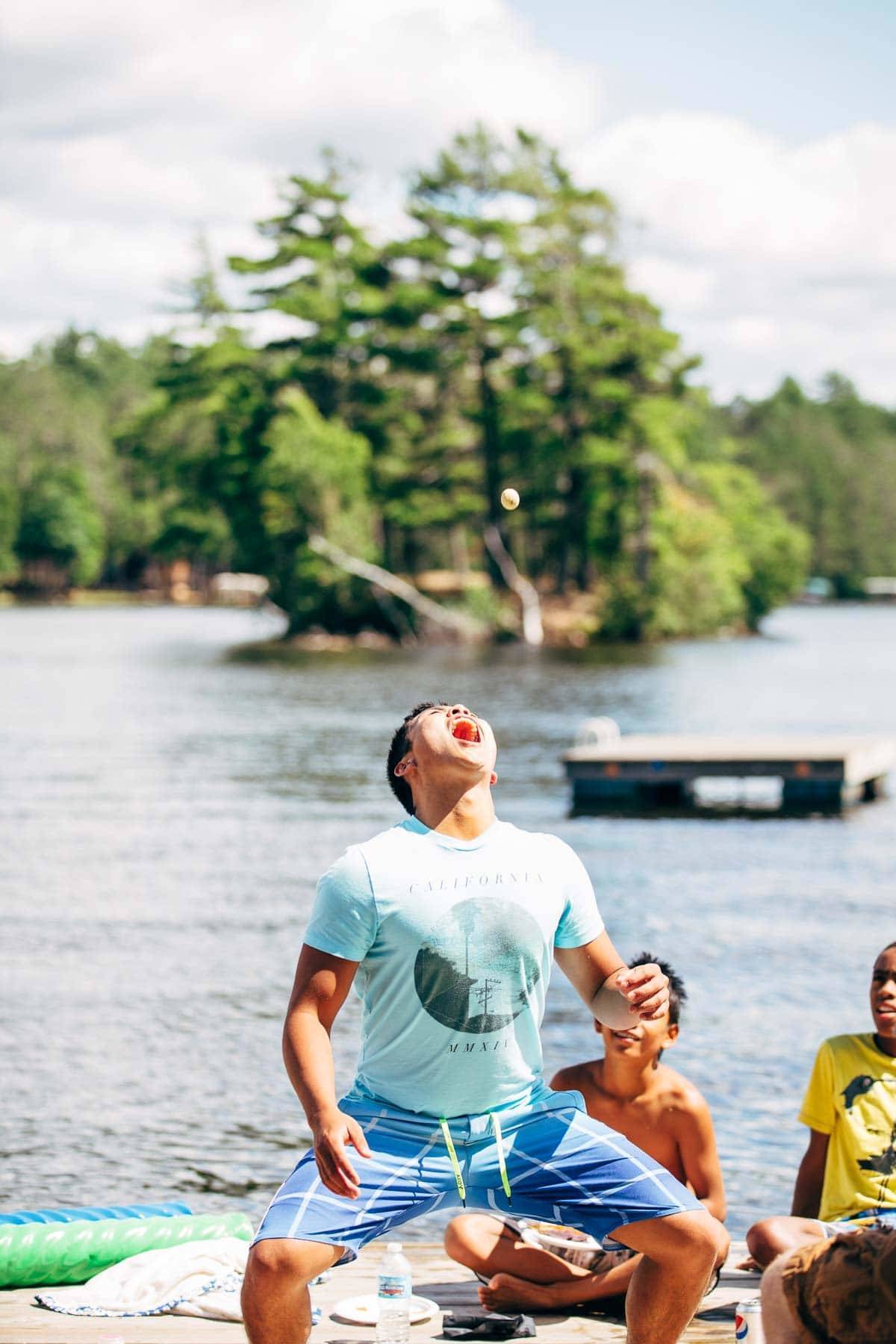 Boy catching food in his mouth.