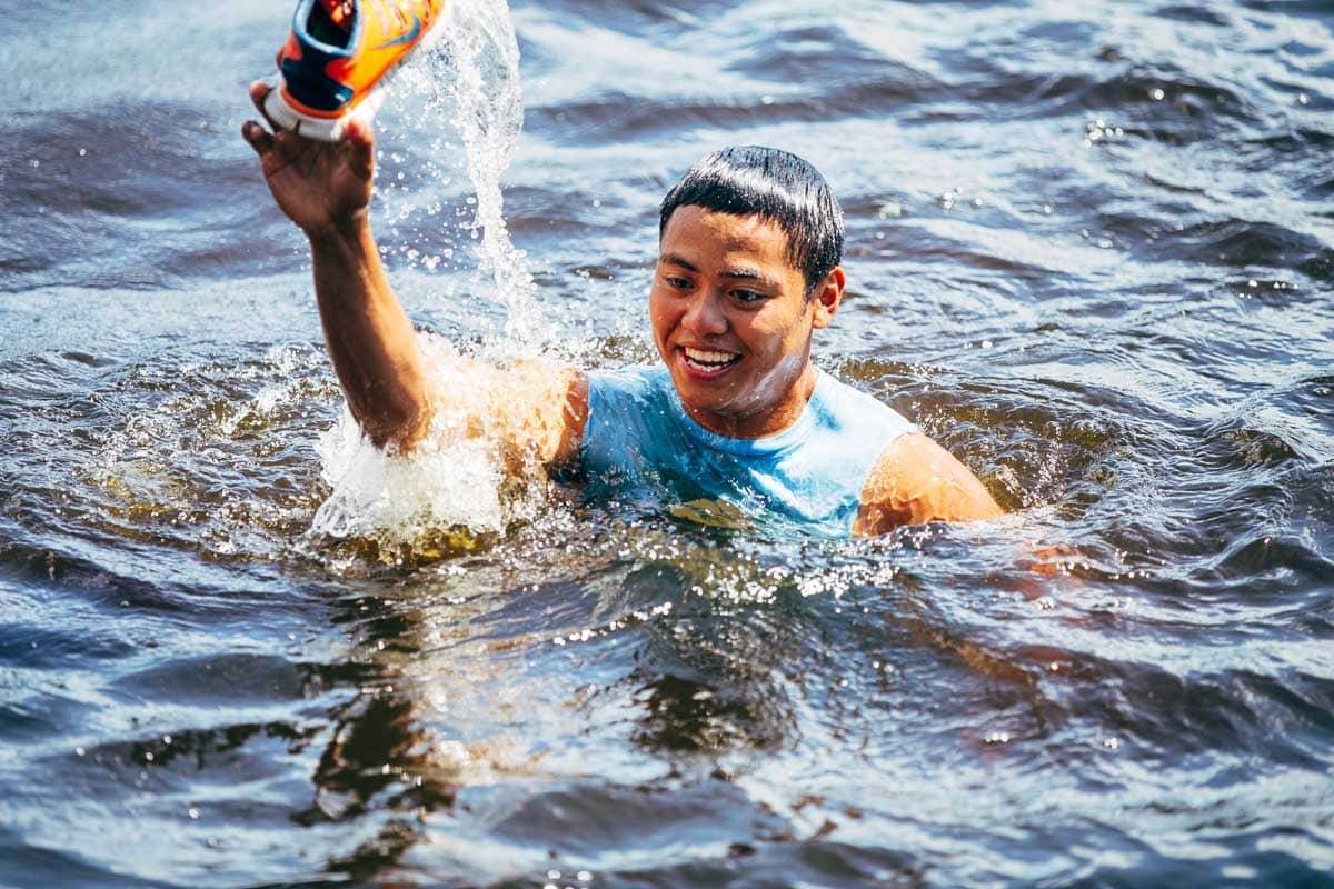 Boy with a shoe in the water.