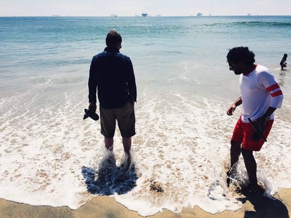 Men standing in ocean water.