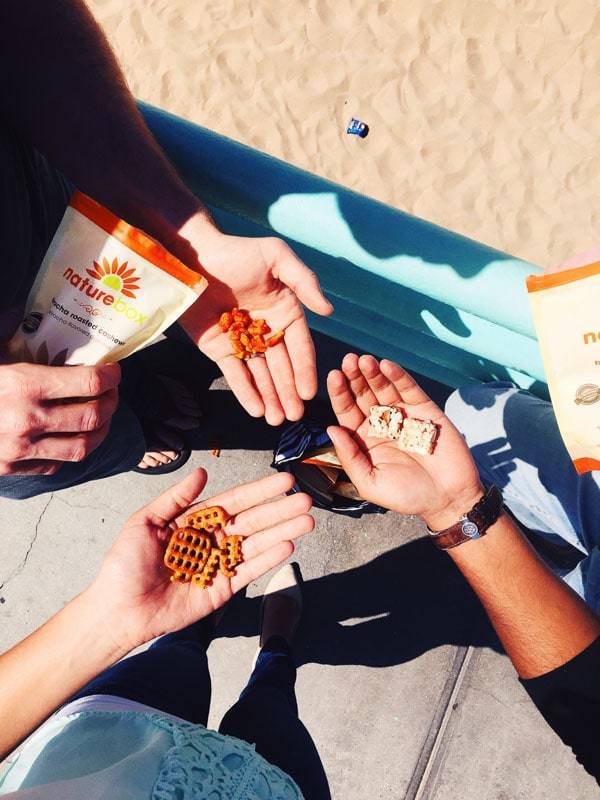 Hands holding snacks.