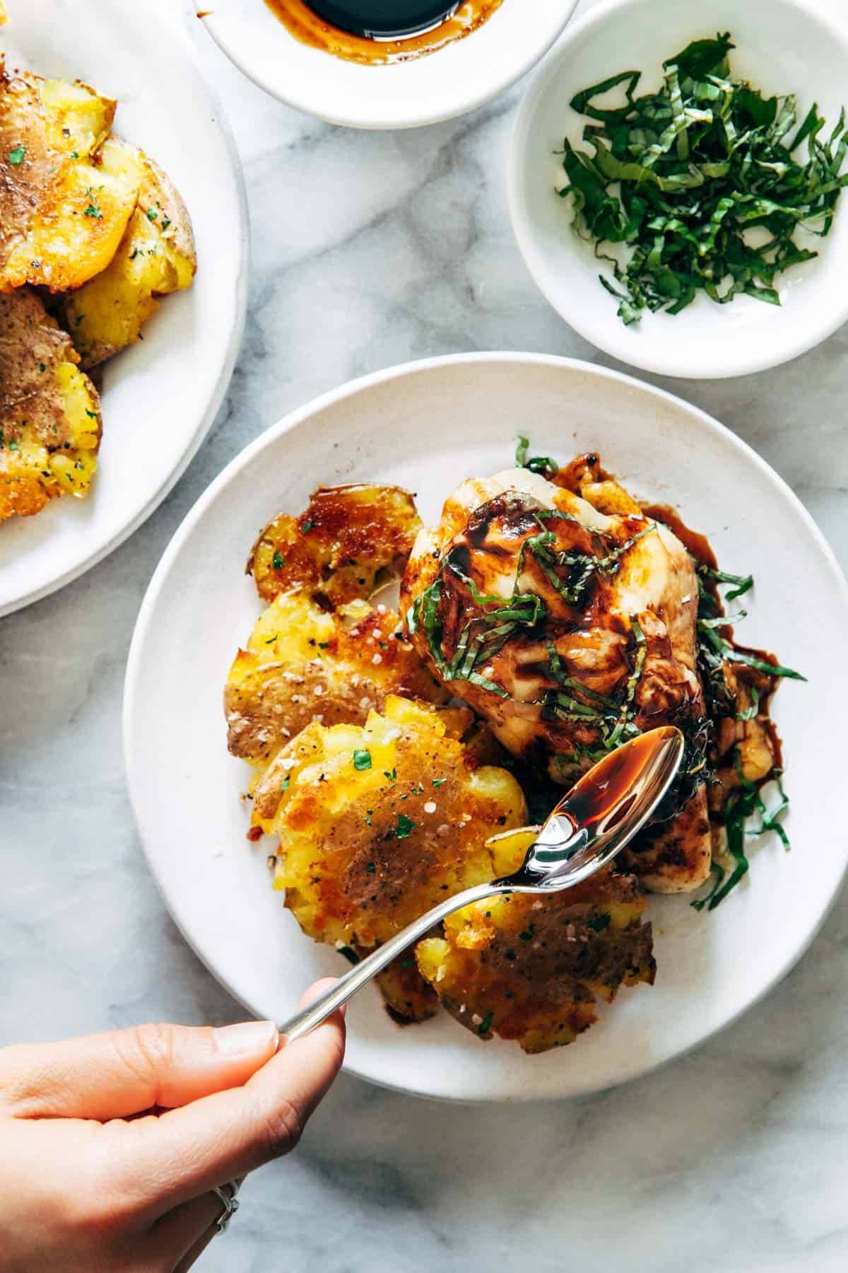 Caprese chicken on a plate with smashed potatoes.