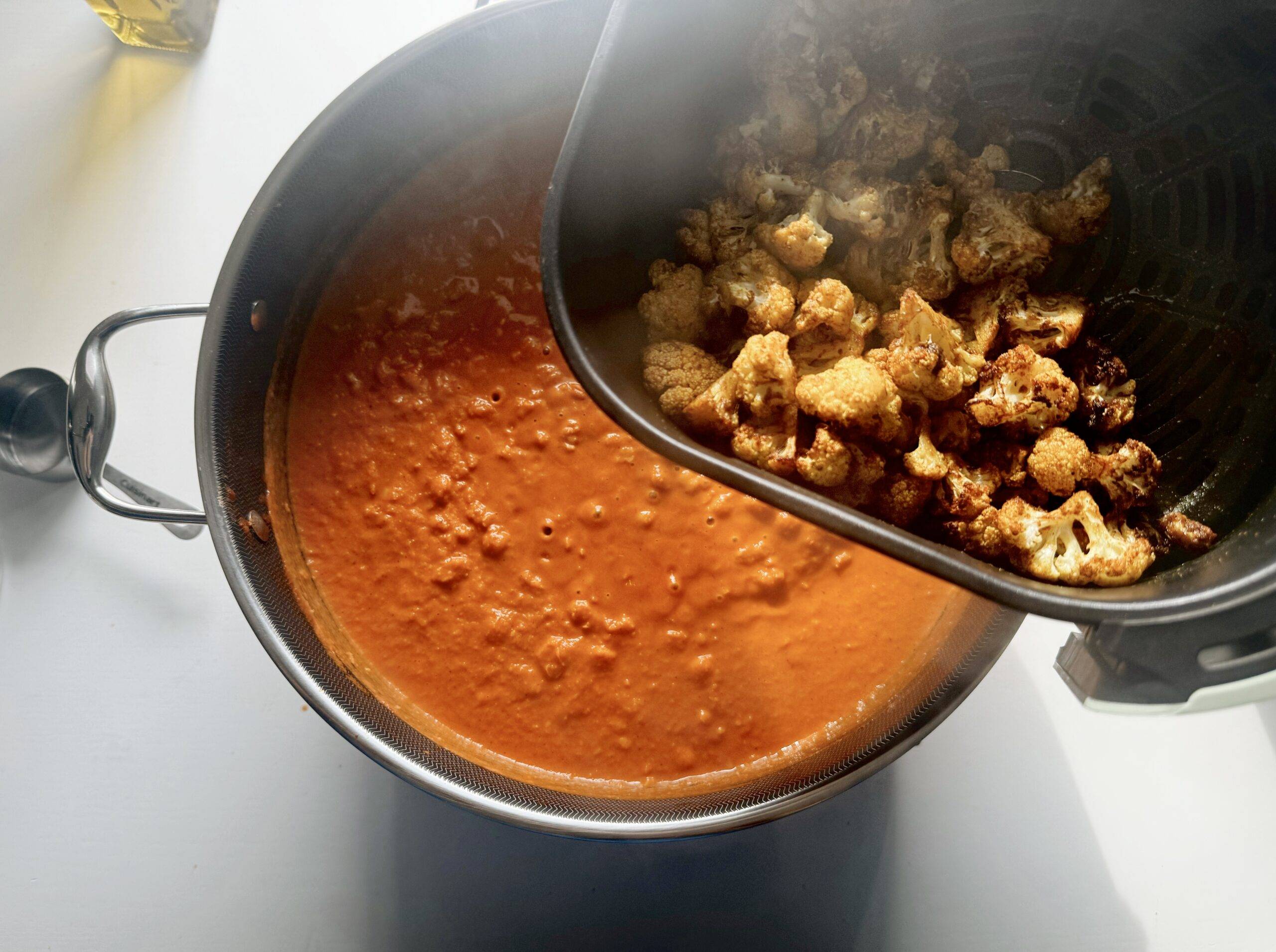 Adding cauliflower to the chickpea sauce mixture.