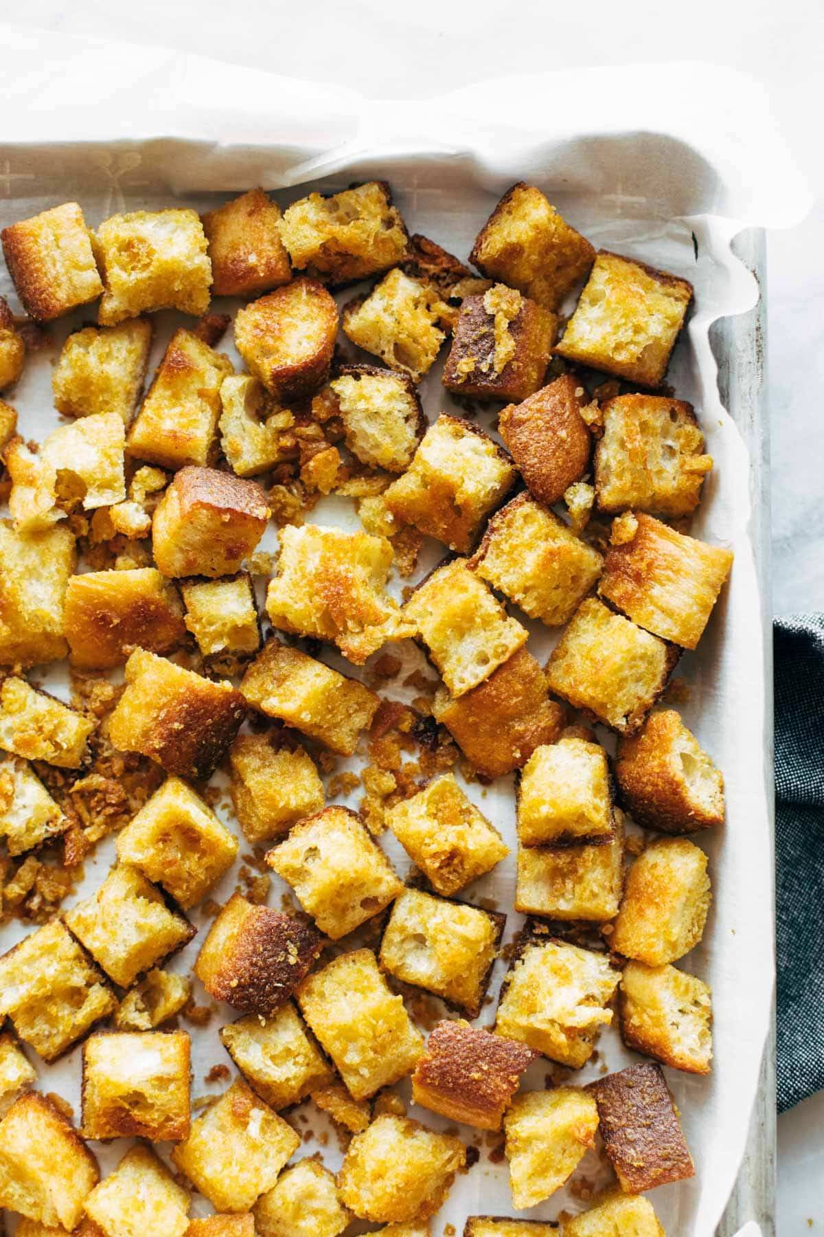 Cheezy garlic croutons on a sheet pan.