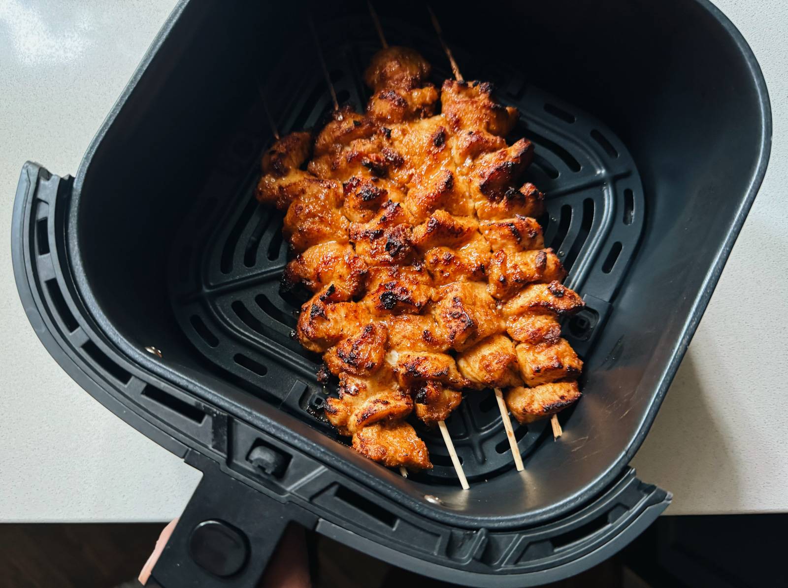 Brown and crispy chicken skewers in an air fryer.