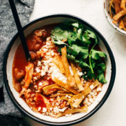 Chicken Tortilla Soup in a bowl with toppings and a spoon.