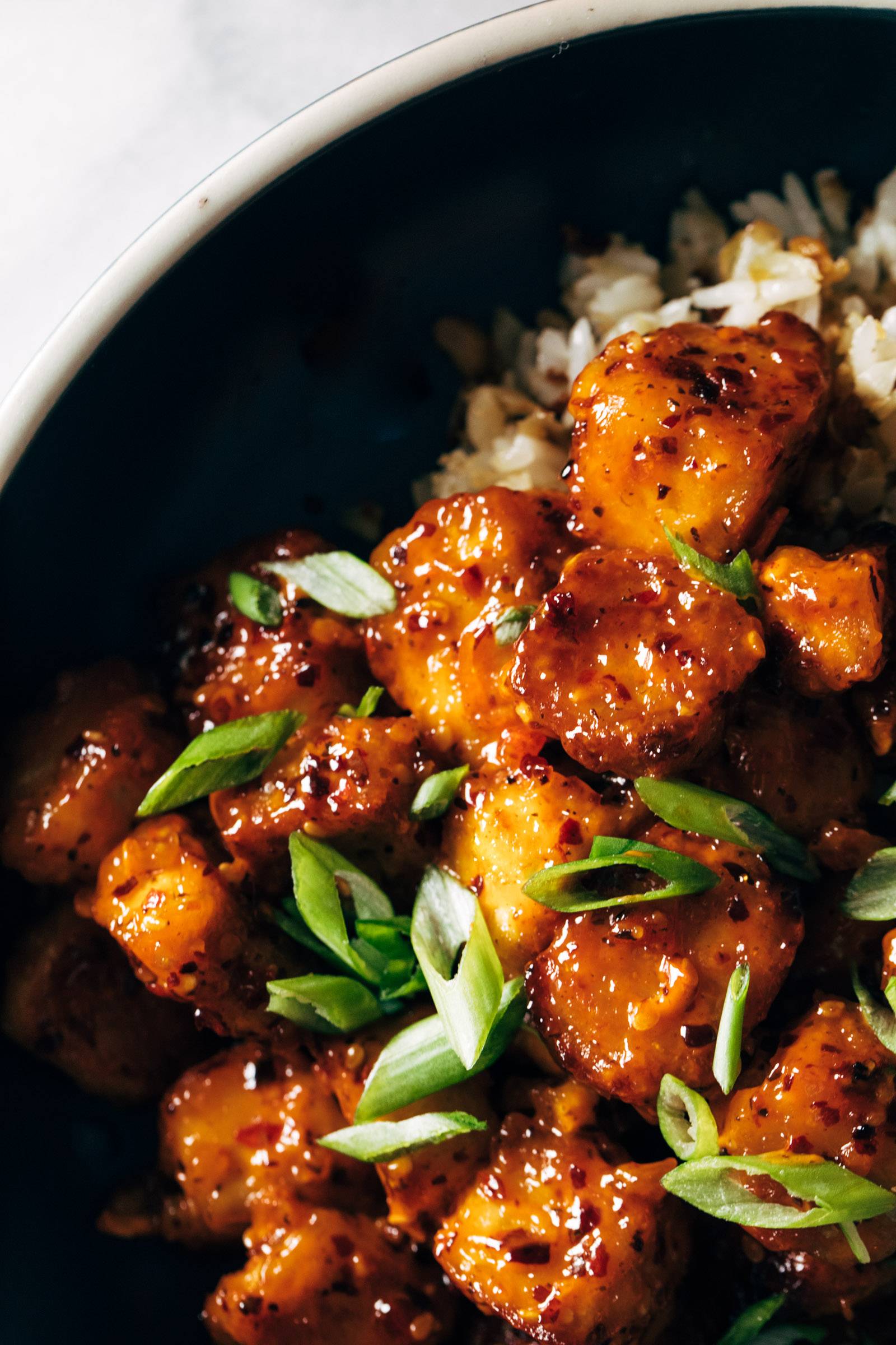 Close-up of chili crunch tofu in a bowl with green onions on top