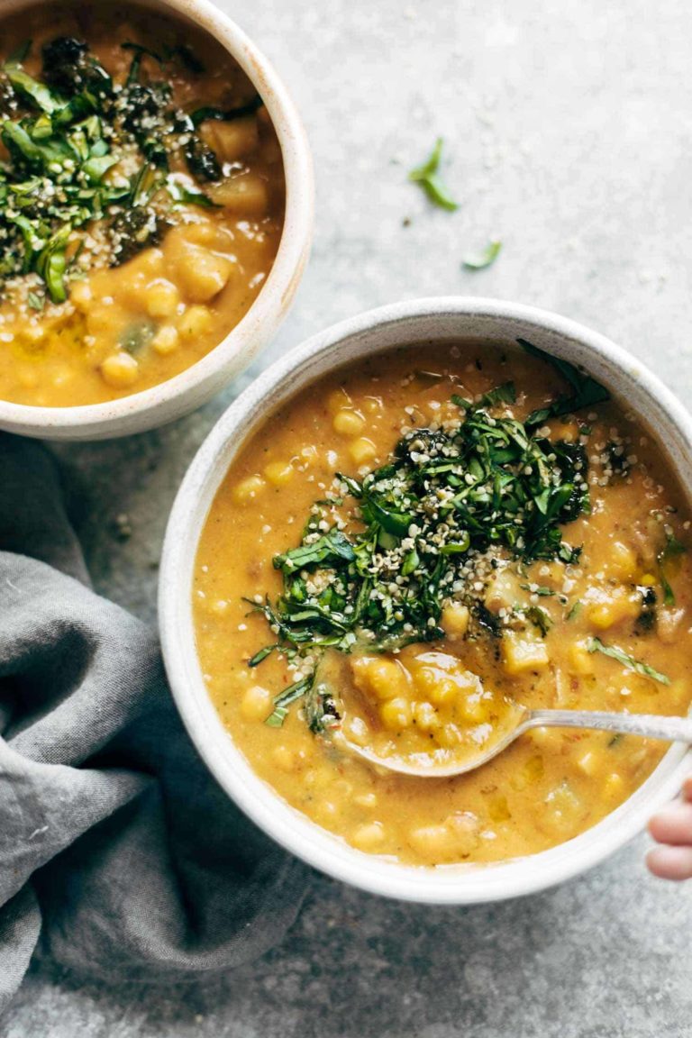 Corn chowder in a bowl with herbs on top.