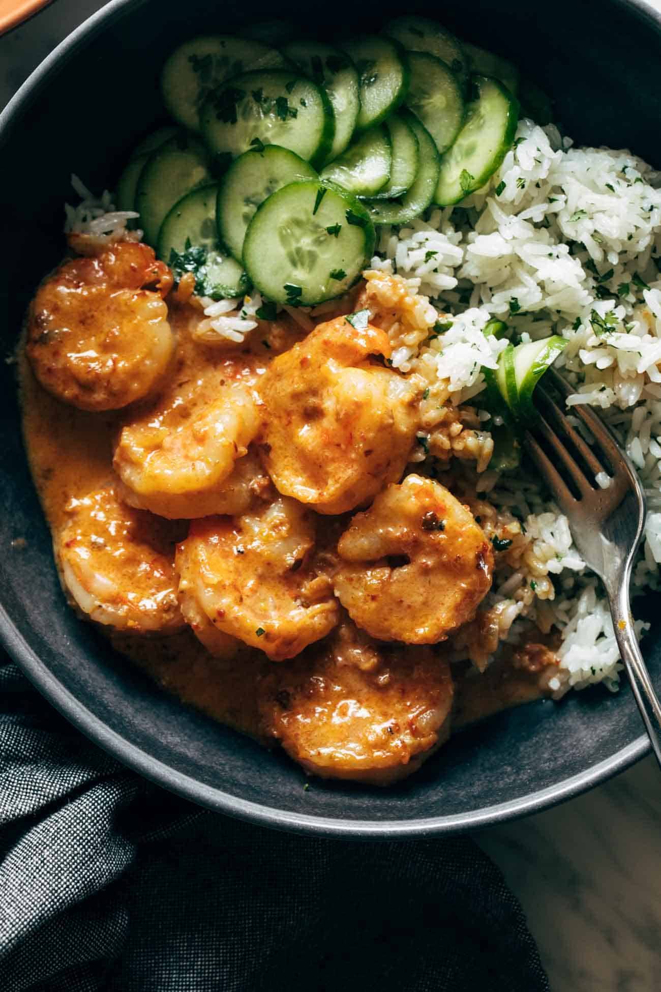 Close-up of chipotle orange shrimp in a bowl with rice and cucumbers