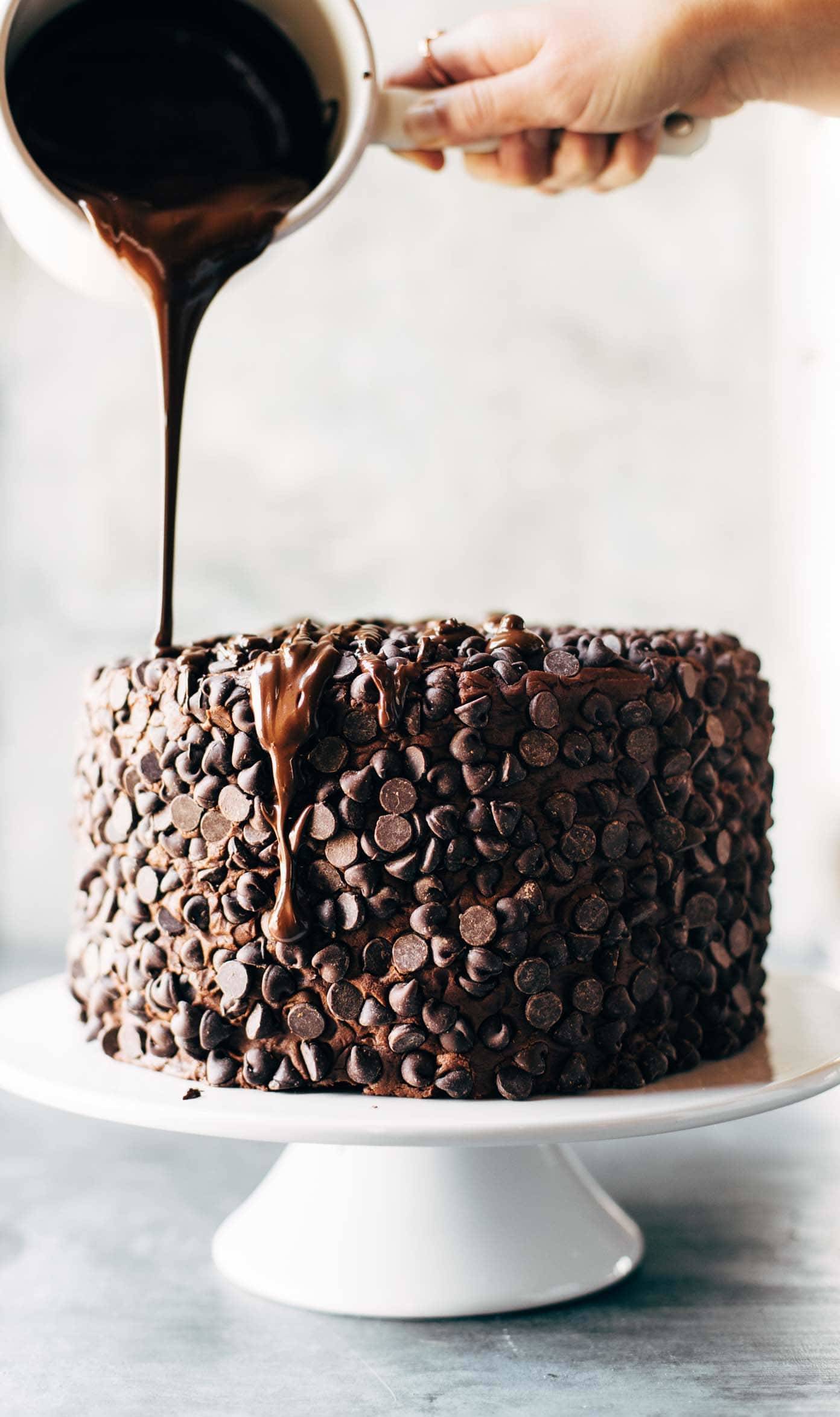 Blackout Chocolate Cake on a cake stand with a chocolate drizzle