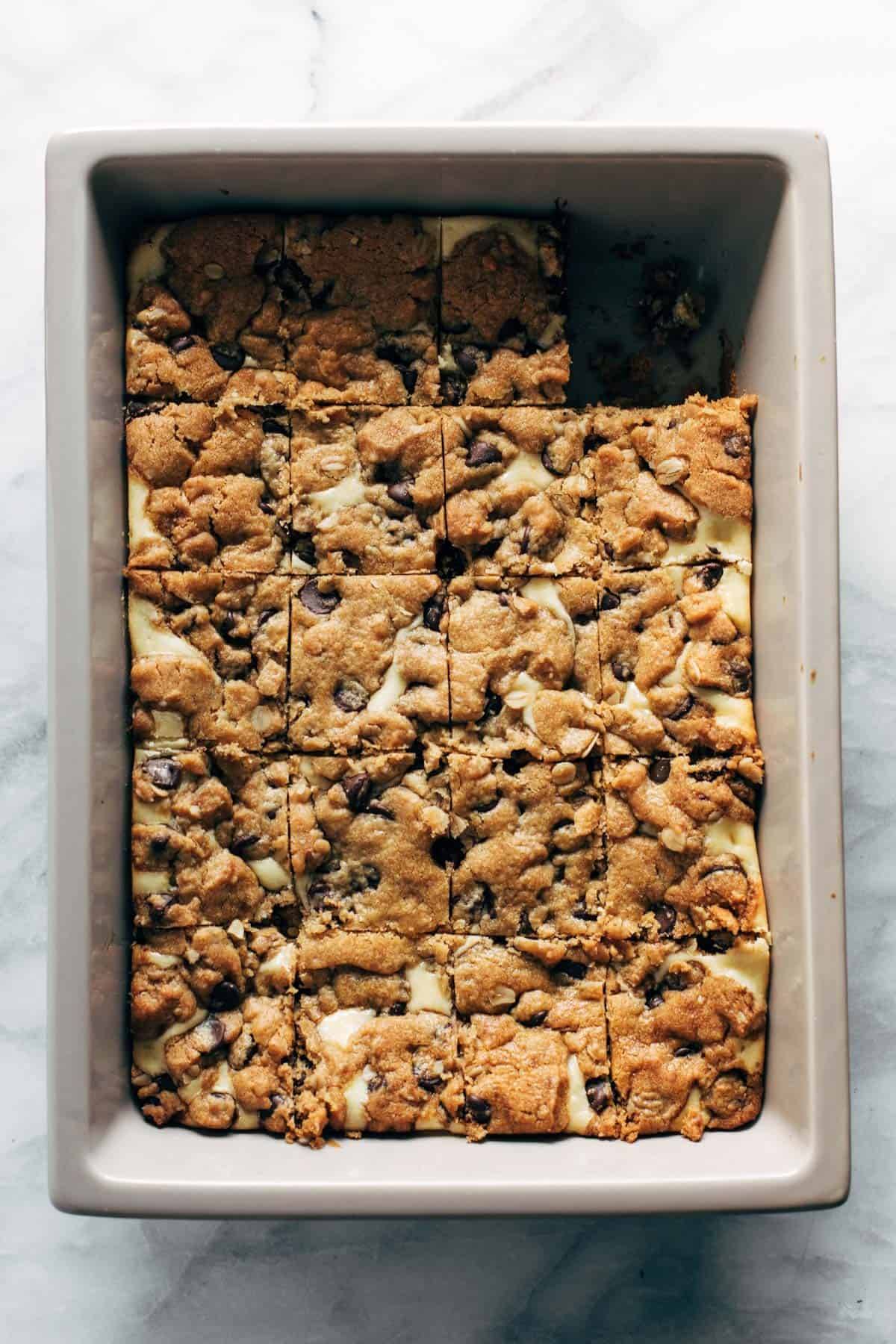 Peanut Butter Chocolate Chip Cookie Cheesecake Bars sliced in a pan.