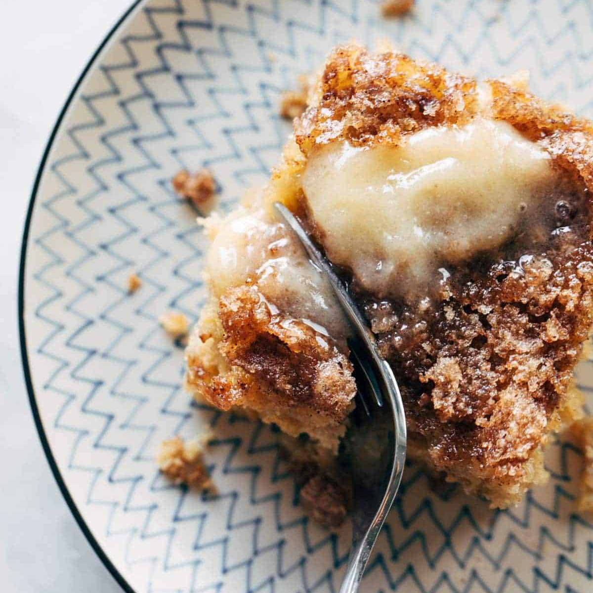 Fork cutting into slices of apple cake