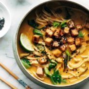 A bowl of curry ramen with tofu in it.