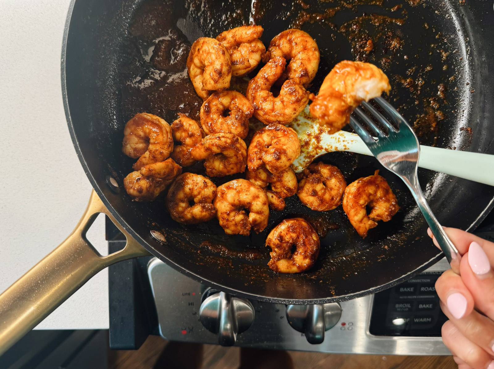 Sautéing shrimp in a pan.